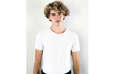 Man in White Shirt and Black Bottoms Standing Against White Wall