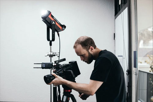 Free Man in Black Crew Neck T-shirt Holding Black and Red Camera Stock Photo