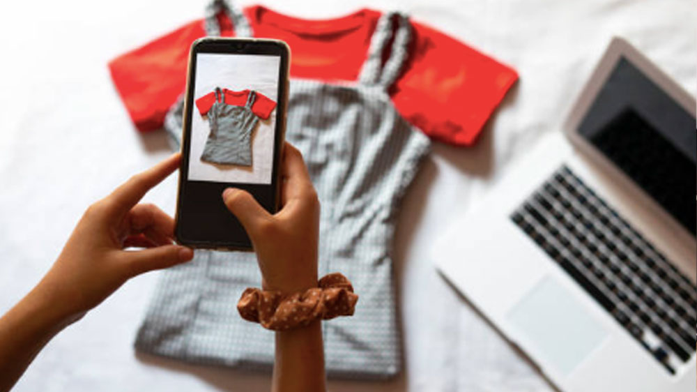 Woman taking a photo of an article of clothing to sell online. Woman taking a photo of an article of clothing to sell online.